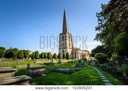Painswick UK - August 17 2015: St Mary's Church and churchyard a blue sky day. Painswick is a town in the Cotswolds originally the town grew on the wool trade.