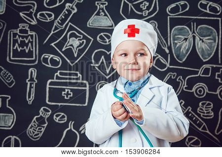 Happy boy playing a doctor holding a sthetoscope - isolated over white