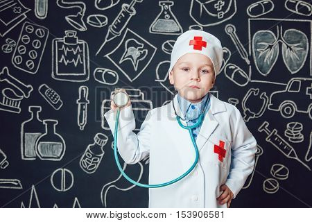 Happy boy playing a doctor holding a sthetoscope - isolated over white