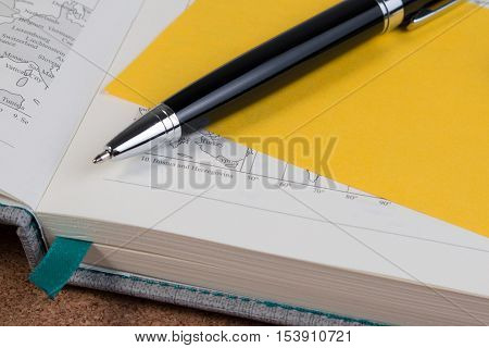 World Atlas Business Diary Book With Yellow Paper Note. Open Business Diary Map Book With World Map
