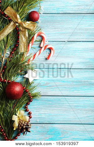 Christmax Tree Branch With Baubles, Candies On Blue Wooden Table