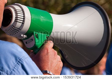 Detail of a scout leader shouting through a green and white megaphone