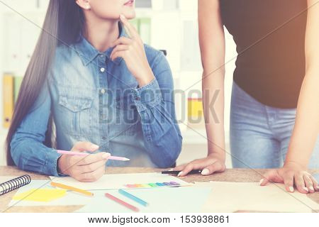 Young painter is listening to her colleague's advise. Concept of learning and mastering your skills. Toned image