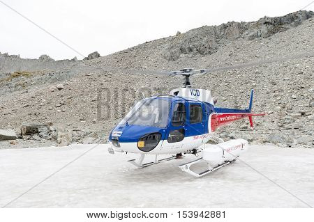 Mount Cook New Zealand - February 2016: Helicopter from The Helicopter Line Company landing on snowcapped mountain peak around Aoraki Mount Cook and Mount Cook National Park.