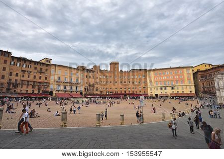 Siena Italy - October 1 2016: Tourists and spectators inside Piazza del Campo in a cloudy day Siena region of Tuscany Italy