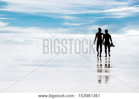 A walk through the heavens . Silhouettes of people on the beach . Friends.