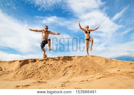 Happy couple on a beach on a background of blue sky and clouds