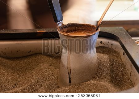Turks With Coffee On Hot Sand. Preparing Coffee In Jezva In Sand. Turkish Method Of Preparing Coffee