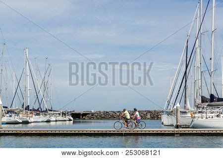 Melbourne, Australia - February 18, 2018: A Couple Cycling Along The Royal Brighton Yacht Club Marin