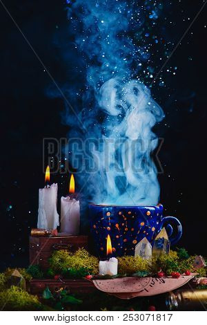 Alchemist Workplace With Burning Candles, Smoke, Crystals, Moss And Potion Bottles. A Magical Concep