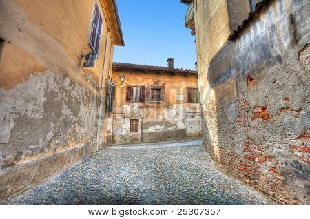 engen gepflasterten Straße unter Jahrgang bunte Häuser in der Stadt von Saluzzo, Italien.