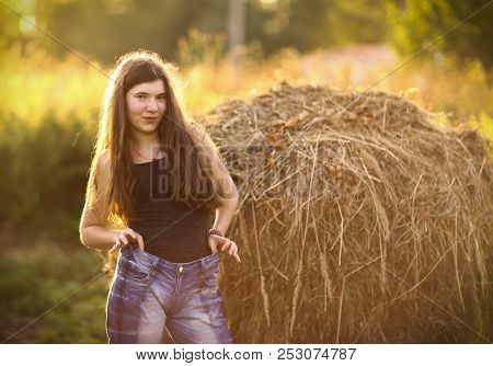 Teenager Farmer Girl With Haystack Close Up Photo On Green Summer Background