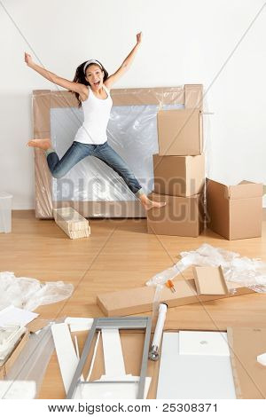 Nuova casa - donna eccitato e felice salto di gioia con le scatole in movimento in movimento. Giovane asiatica caucasica wo