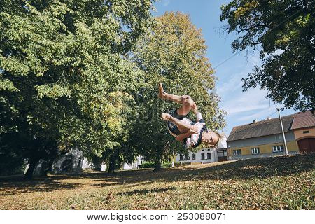 Boy Practicing Free Runnuing In Public Park And Jumping Upside Down.