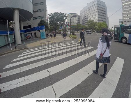 Fukuoka, Japan - April 27, 2016: Typical Japanese School Girl Is Crossing The Street