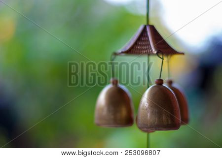 Three Golden Lucky Bells Hanging Down From The Celling By Rope Focused On The Front Bell While The G