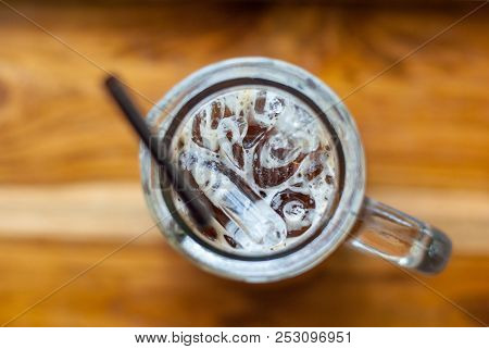 An Iced Espresso Coffee In Tall-shape Glass With Brown Plastic Straw In The Center Of Photo Focused 