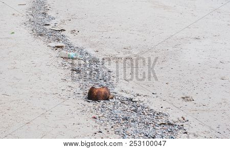 Sea Beach Having A Rock, Coconut Shell, And Gabage Aligned In One Line, Trash Pollution, Environment