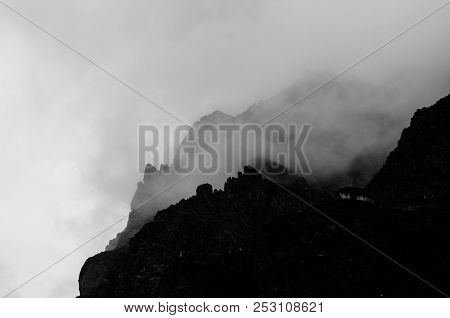 Silhouette Of Mountains Can Be Seen From Behind The Clouds