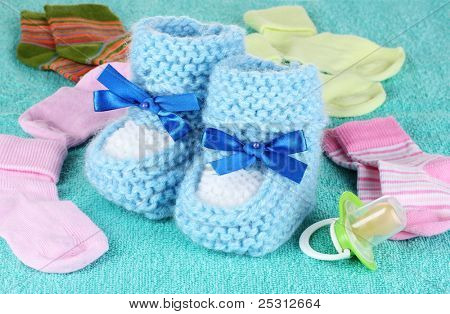 Blå baby støvletter, sokker og sut på blå baggrund