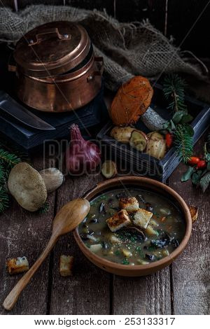 Mushroom Soup In Ceramic Bowl With A Copper Pan And Mushroom In Background, Dark Photo.