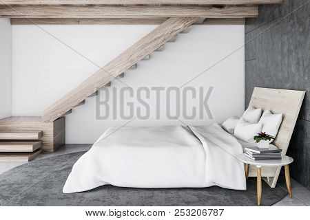 Scandinavian Style Bedroom Interior With White Walls, A Concrete Floor With A Carpet, Stairs, And A 