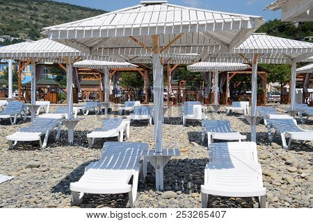 Sun Loungers Under A Canopy. Infrastructure Of The Beach, Protection From The Sun.