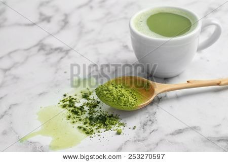 Cup Of Fresh Beverage And Spoon With Powdered Matcha Tea On Table