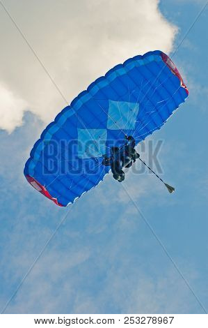 Low Angle View Of Para-glider With Blue Parachute On A Blue Sky