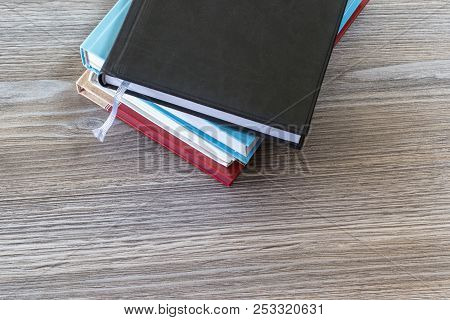 Close Up Top View Photo Of Pile Of Book On Wooden Grey Table