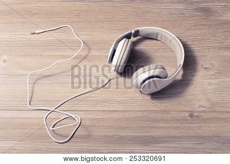 White Headphones On A Table Isolated Wooden Background