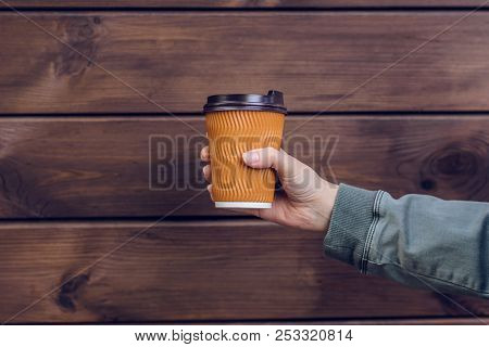 I Love Coffee! Person's Hand Holding Cup Of Coffee In Front Of Brown Wooden Background