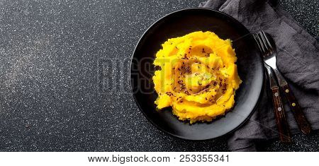 Mashed Potato With Pumpkin In Black Bowl. Dark Background. Top View