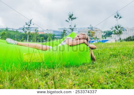 Young Woman Resting On An Air Sofa In The Park.