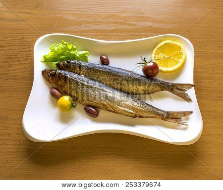 Smoked Sprats Or Baltic Herring Served With Vegetables And Greens And Placed On White Plate, Traditi