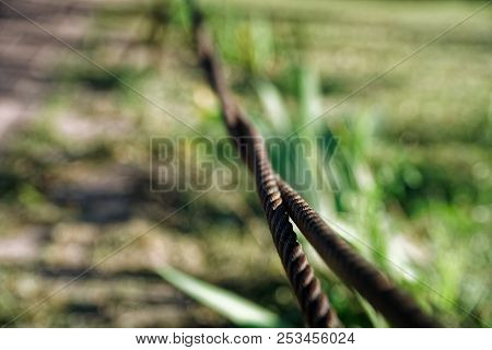 Thick Steel Rope Close Up. Bridge Fence Element. Detailed View. The Surface Of The Steel Cable Is Co