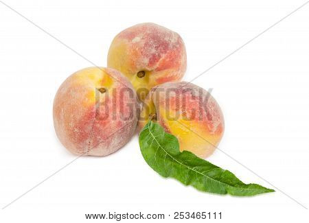Three Ripe Fresh Peaches With Leaf On A White Background