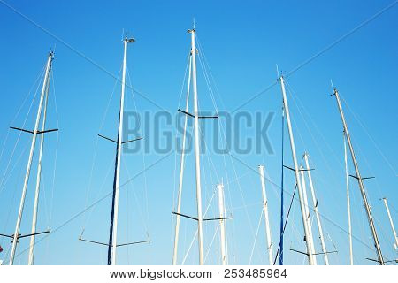 Many Yacht Masts Against The Blue Sky. Marine Concept.