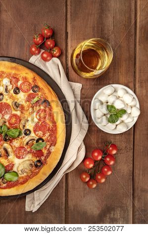 An Overhead Photo Of A Pepperoni Pizza With A Glass Of White Wine, Cherry Tomatoes And Mozzarellini 