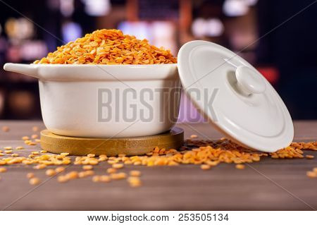 Lot Of Whole Raw Red Lentils In A Ceramic Stewpan With Restaurant In Background