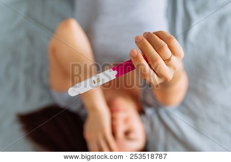Sad Woman On Bed With Negative Pregnancy Test