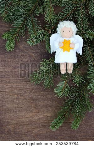 White Felt Christmas Angel With Yellow Star In Hands To Fresh Natural Branches Of Christmas Tree Spr
