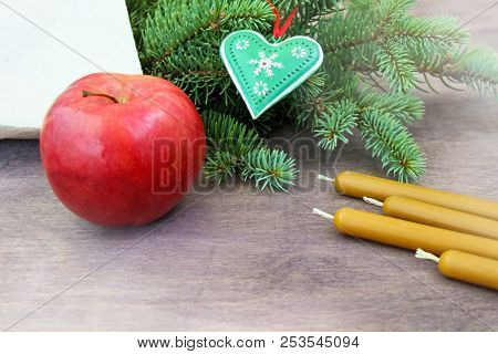 Christmas Party Preparation Background With Red Apple, Natural Wax Candles Near Fresh Natural Branch