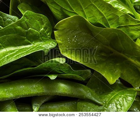 Close-up organic fresh green vegetables background. The green spinach ang peas for cooking a vegetarian salad. Clean detox food.