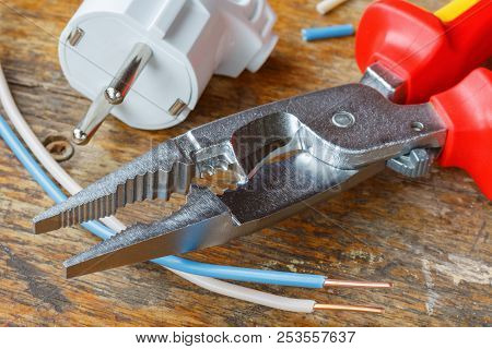 Combination Pliers For Wiring With Electrical Plug And Copper Wires On Wooden Table In Workshop