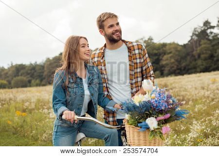 Smiling Young Lovers With Retro Bicycle In Field With Wild Flowers