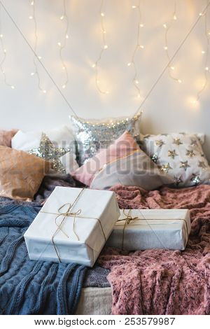 Xmas In Morning Bedroom. Double Bed In Christmas Interior On White Wall Background With Cozy Lights.
