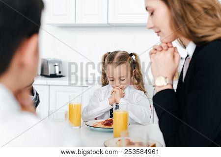 Partial View Of Family Praying Together During Breakfast At Home