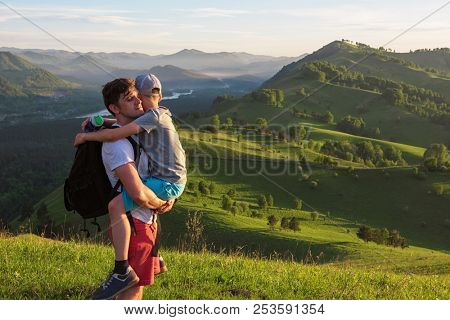 Travel, family and real life concept - happy father and son on the altai mountains background