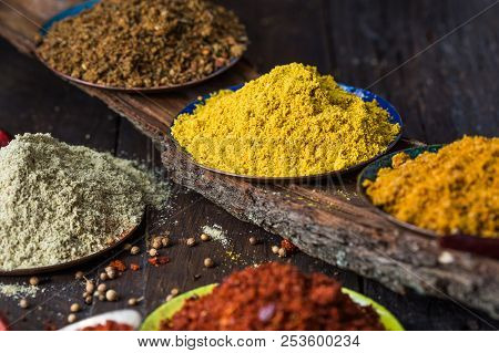 Heaps Of Various Ground Spices On Wooden Background. Georgian Spices, Indian Spices, Arabian Spices